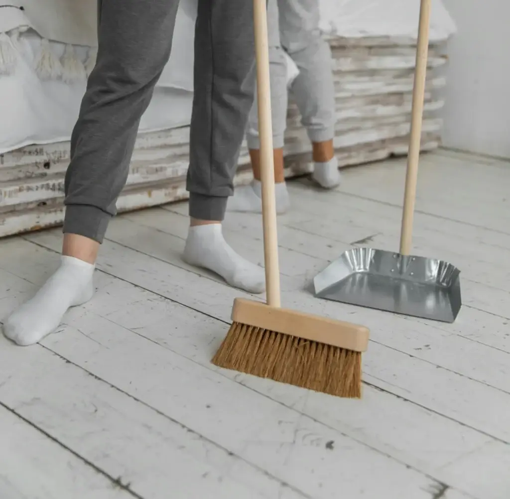 woman sweeping dusty floors