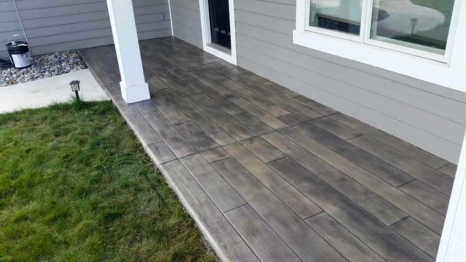 Rustic Concrete Wood coating on a covered porch — weathered gray-brown wood grain texture applied over concrete