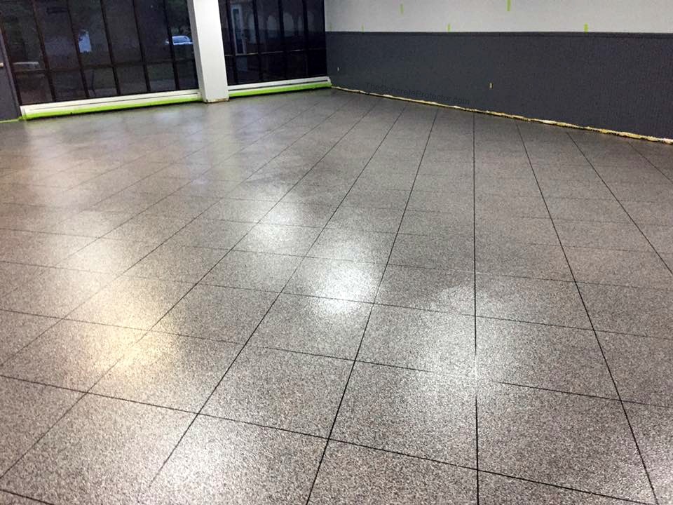 Epoxy tile flooring in a commercial space — charcoal gray large format tile pattern with high-gloss polyaspartic finish