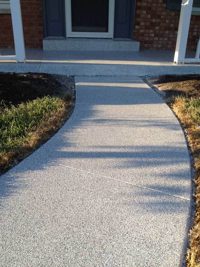 Granitflex concrete coating on a residential front walkway and porch — gray aggregate blend